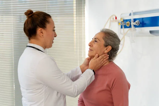 Doctor checking senior woman's lymph nodes in doctor´s office