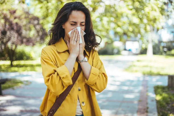 Woman has sneezing. Young woman is having flu and she is sneezing. Sickness, seasonal virus problem concept. Woman being sick having flu sneezing.