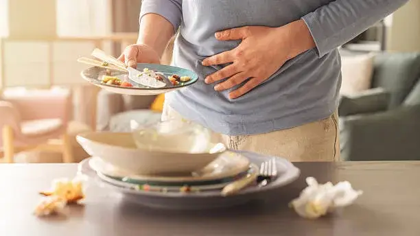 Woman with bloating and stomach ache from overeating